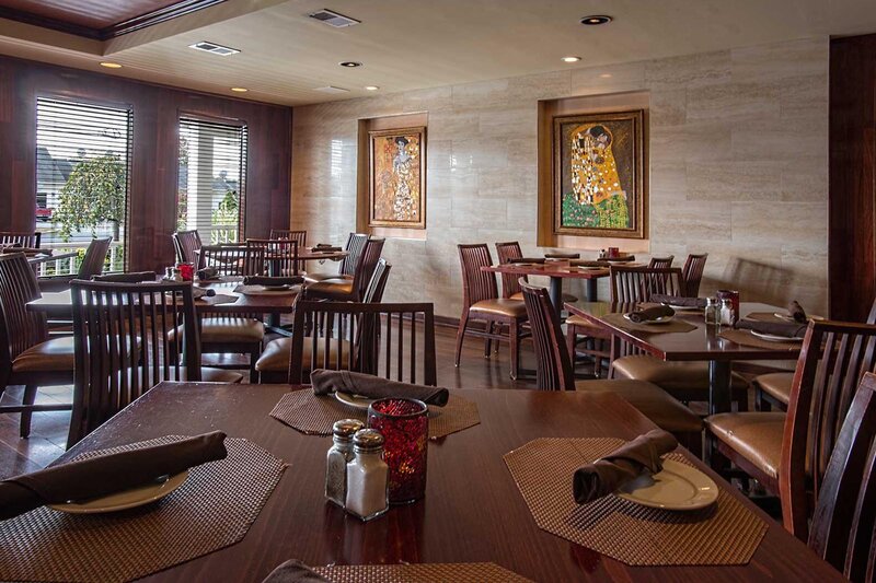 Dining area with six tables, walls decorated with paintings